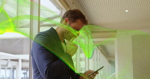 Scrolling man tapping phone screen by windows in corridor, in navy blazer, green Stock Footage 331027069