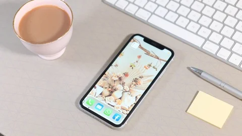 Scrolling through Apps on a smartphone laid on a desk Vídeo Stock 124095868