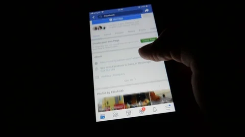 Scrolling through Facebook on an iPhone Video stock 98917221