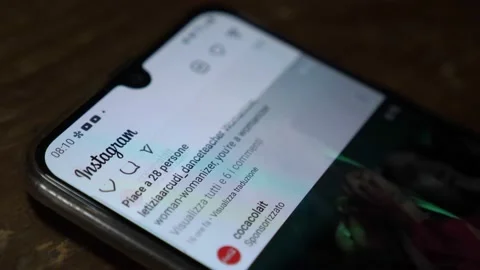 Scrolling through Instagram posts on a smartphone's touchscreen Stock Footage 165874453