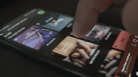 Scrolling through Spotify Playlist on mobile phone Stock Footage 197468660