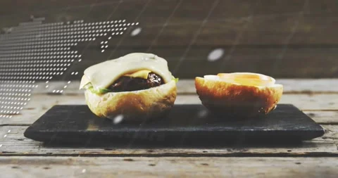 Scrolling world-map overlays covering and revealing two bun halves on wooden Stock Footage 331713384