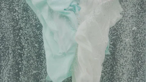 Scrubbing clothes under water with bubbles in the background Stock Footage 216760731