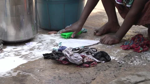 Scrubbing laundry in slum Stock Footage 63556798