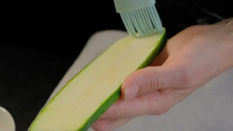 Scrubbing a Zucchini Slice with a Brush in Cooking Stock Footage 341461891