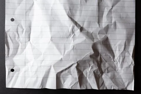 Scrunched up, hole punched sheet of lined white notebook paper, on black Stock Illustration