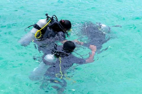 Scuba dive training in the sea with a instructor teaching students Stock Photos