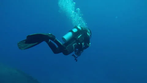 Scuba diver with camera in hand leaves wreckship of Salem Express ferry Stock Footage 327459090