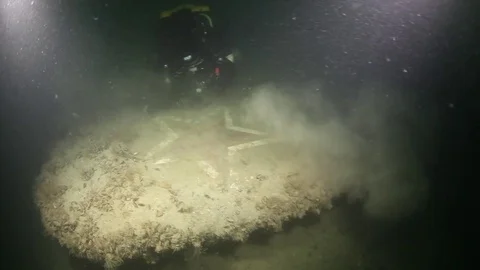SCUBA diver cleaning a wing of Soviet plane wreck from silt underwater Stock Footage 82731415