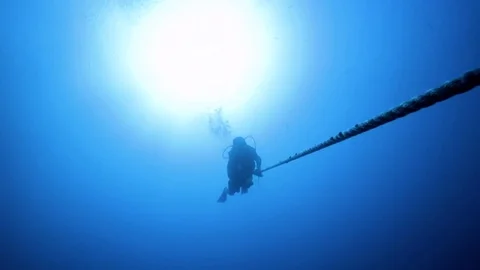 Scuba diver climbing down a rope into the ocean 스톡 동영상 80431793