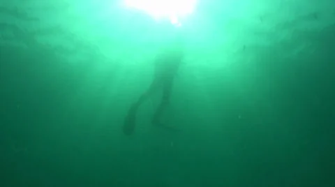 Scuba diver descending through deep water and sun rays Stock Footage 33071728