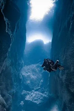Scuba diver exploring ocean canyon with sun rays Stock Photos
