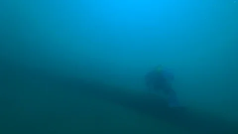 Scuba diver floating above the pipe Stock Footage 99410473