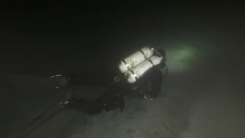 Scuba diver illuminates the bottom of the lake, Albano lake, Italy Stock Footage 107789316