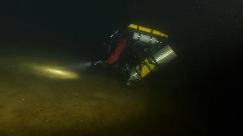 Scuba diver lights with the torch the bottom of the lake, Albano lake, Italy Stock Footage 107562568