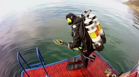 Scuba diver with metal detector jumps from a boat into the water  Stock Footage 62332453
