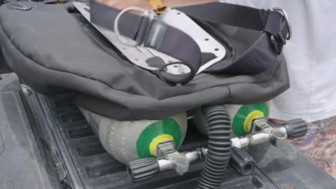 Scuba diver preparing and assembling a backplate and wing system on twin tanks Video stock 340346455
