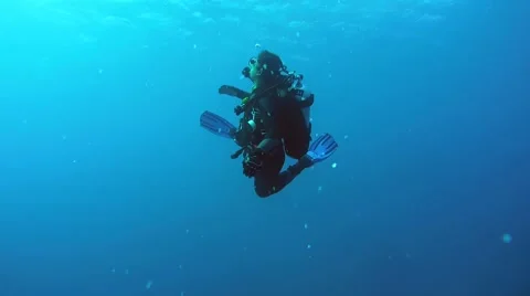 Scuba diver is spinning on its axis looking for his running mate Vidéo 62331015