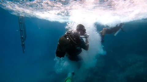 Scuba diver steps off boat into water, s... | Stock Video | Pond5