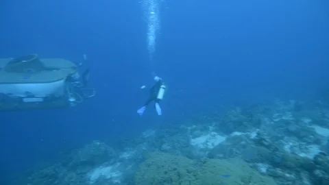 Scuba diver with submarine floating under blue sea Stock Footage 99081124