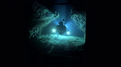 Scuba diver swims inside the wreck tunnel at night - Cousteau's precontinent  Stock Footage 61120097