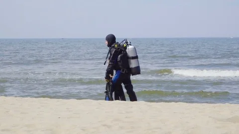 Scuba diver walking back to shore along the sea coast. Stock-Footage 76652962
