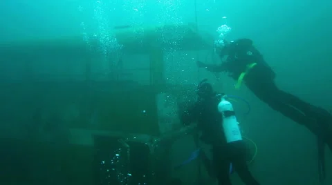 Scuba Divers approach the wreck of a Double Decker Bus Stock Footage 48586134