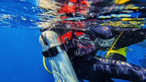 Scuba Divers Boarding rusty Dive Boat on Open Ocean Surface Under Clear Blue Sky Stock Footage 334262682