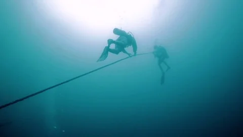 Scuba divers descending down a long rope from a boat into the ocean 스톡 동영상 80439602