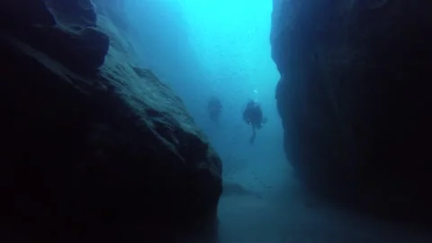 Scuba Divers entering a cave Stock Footage 157991788