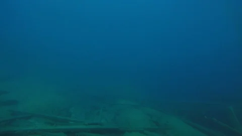 SCUBA divers explore a ship wreck in blue water as seen from a GoPro Stock Footage 115011426