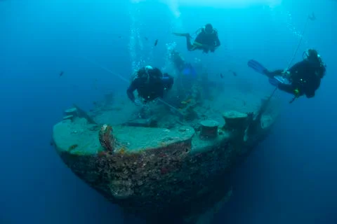 Scuba divers exploring the bow of SS Thistlegorm shipwreck. red sea, egypt. Stock Photos