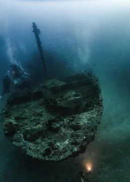 Scuba Divers Exploring Sunken Shipwreck Underwater Stock Photos