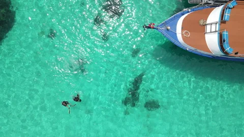 Scuba divers floating over turquoise water near the boat at Racha Island, Phuket Stock-Footage 314819337
