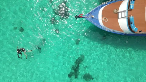 Scuba divers floating over turquoise water near the boat at Racha Island, Phuket Stock-Footage 314819352
