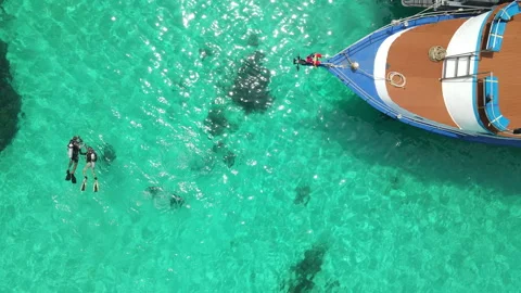 Scuba divers floating over turquoise water near the boat at Racha Island, Phuket Stock-Footage 314819853