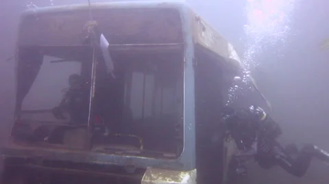Scuba divers having fun on the wreck of a bus Stock Footage 48579384