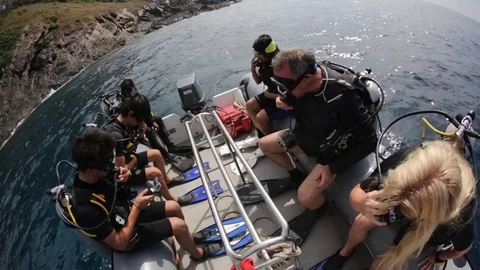 Scuba divers rolling out of small boat into water Stock Footage 77734597