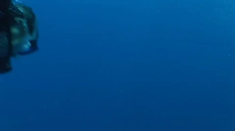 Scuba Divers Swim Through Frame with a Scooter Stock Footage 5253043