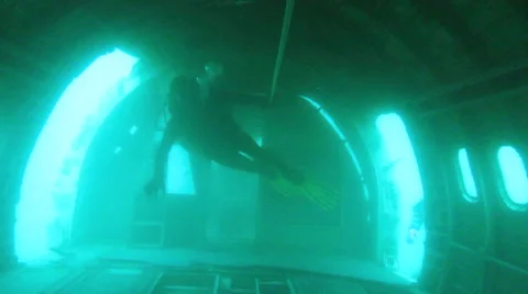 Scuba divers swim through a plane wreck - blows a kiss at the end. Stock Footage 48587448