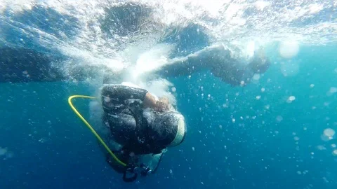 Scuba diving - Driver falling from surface in slow motion Stock Footage 117186572
