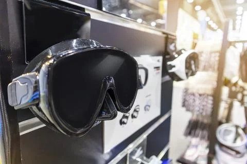 Scuba diving goggles hanging in a diving equipment shop Stock Photos