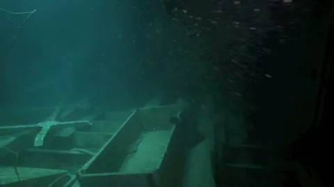 Scuba diving inside hull of small shipwreck on ocean floor Stock Footage 48028139