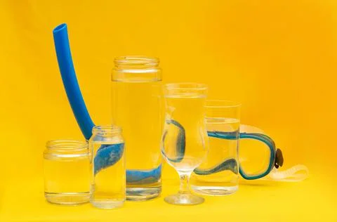 Scuba diving mask distorted through glasses with water. Yellow background Stock Photos
