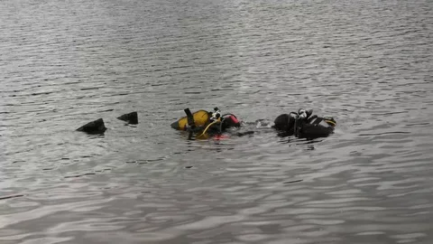 Scuba diving in a mountain lake, practicing techniques for emergency rescuers Video stock 111060463