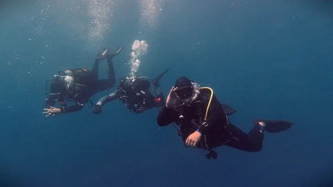 Scuba diving - Three drivers going deeper Stock Footage 117187654