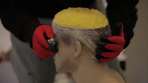 The sculptor cuts the sponge which is in the doll's head Stock Footage 86822822