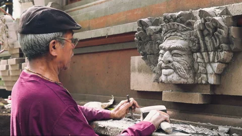 Sculptor hewing stone face on wall Stock Footage 86558805