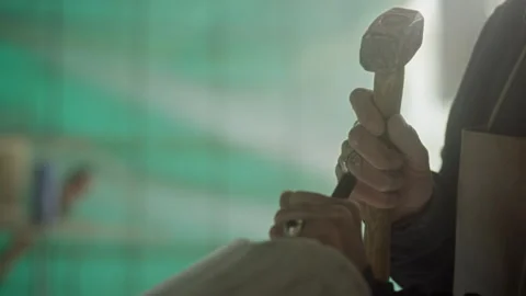 Sculptor hitting a chisel with a hammer while sculpturing stone Stock Footage 274999768