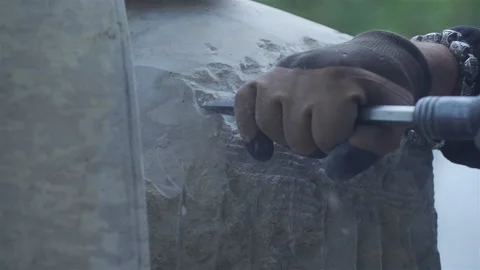 Sculptor with a mechanical chisel builds a figure out of stone Stock Footage 163005974